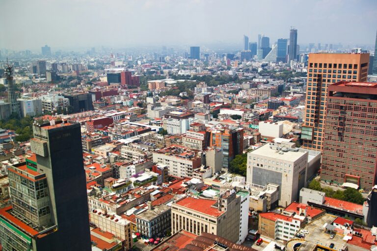 Vista panorámica de la Ciudad de México, representando los sectores clave de la economía mexicanaPanoramic view of a sprawling cityscape with modern skyscrapers.